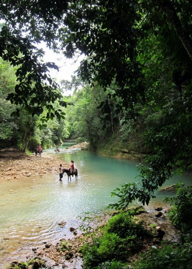 Horseback riders crossing a river near El Limón